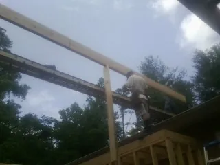 Carpenter setting a ridge beam over a new addition frame — Ice Dam Removal by Roofing Brothers in Cross Plains
