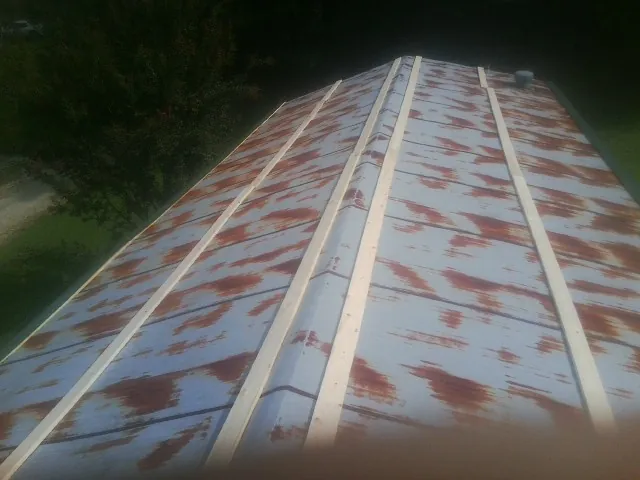 Rusted metal roof panels with new wood purlins before replacement — Storm Damage Roof Repair in Cross Plains by Roofing Brothers